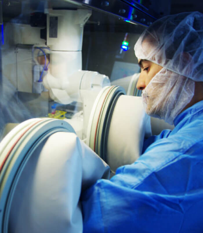 Laborantin qui manipule un isolateur de laboratoire